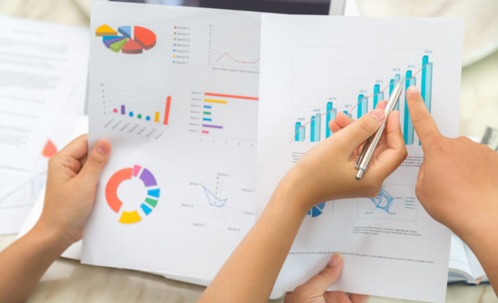 Group of business people pointing at business document during meeting